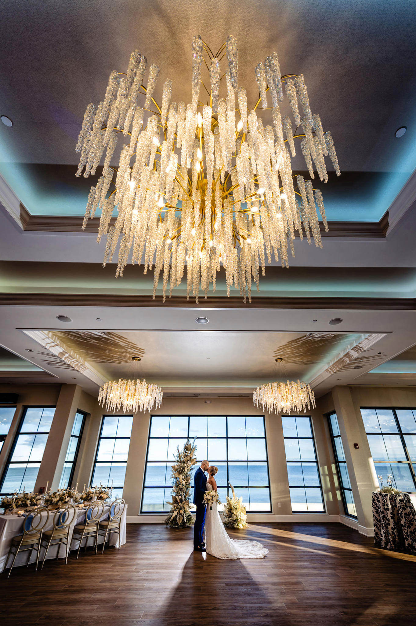 Natural light flooding the ballroom through south-facing windows during reception setup