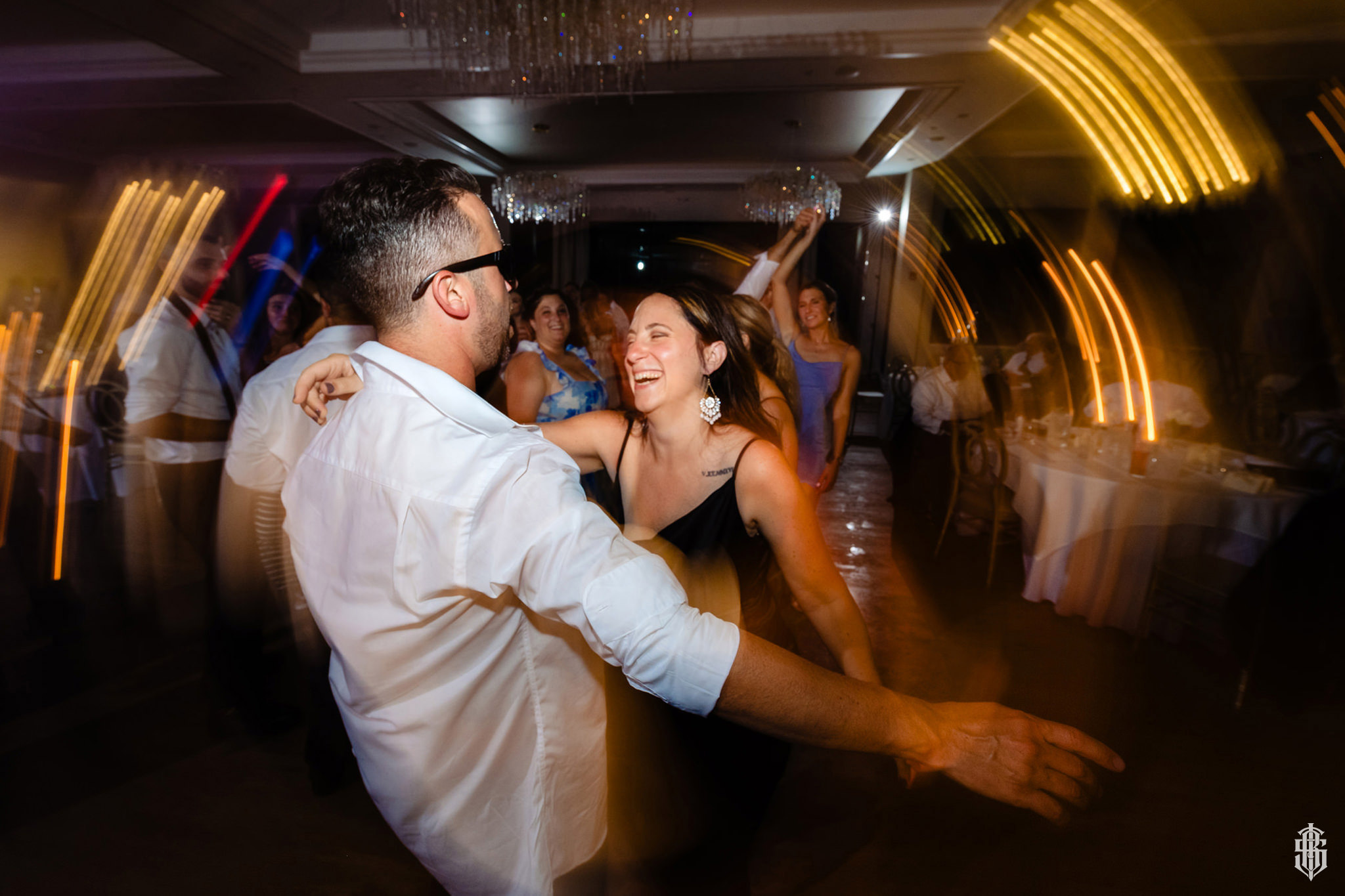 Guests celebrating on the dance floor with warm chandelier light overhead