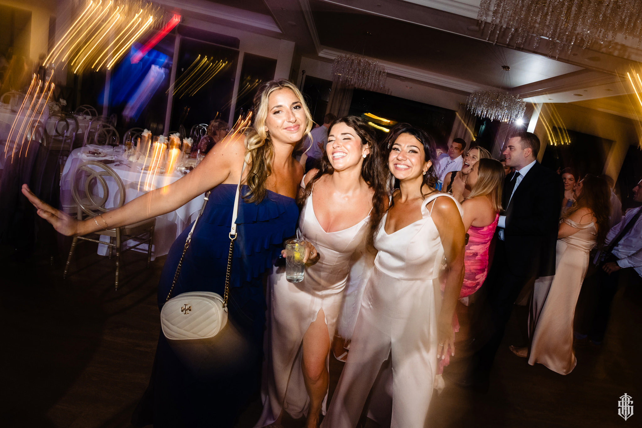 Couple laughing together during toasts with the wedding party behind them
