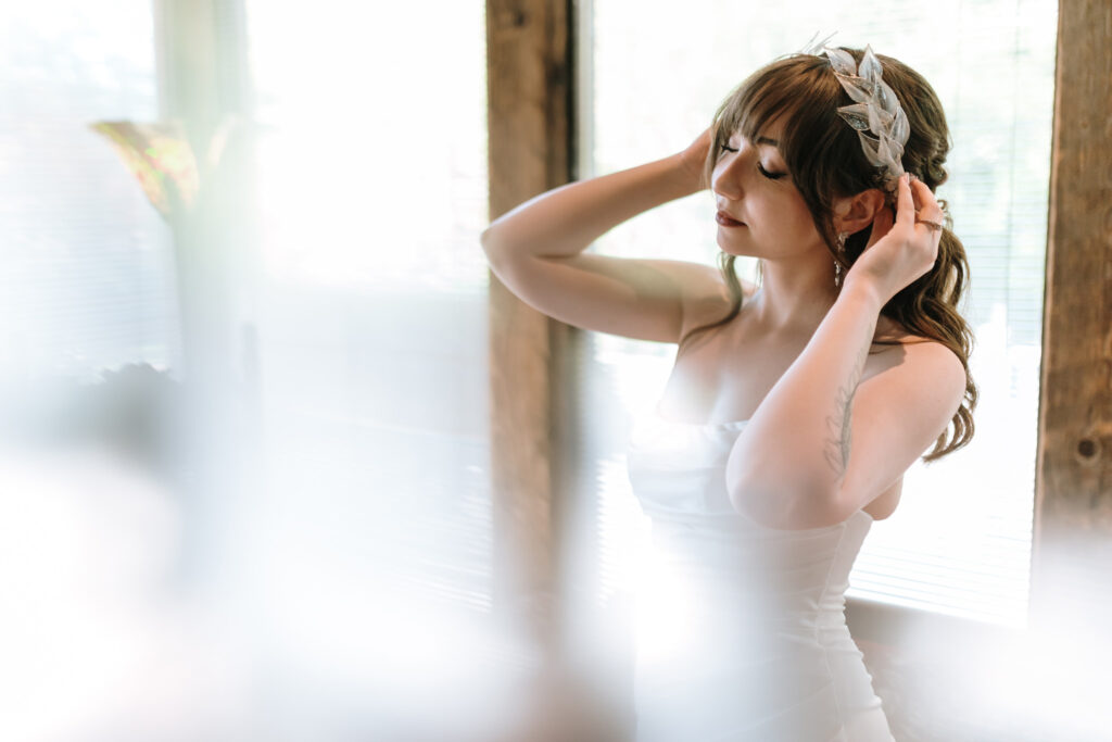 Candid moment of the bride adjusting her hair piece at the bridal suite of Bill Miller's Castle Bruno Sauma Photography 